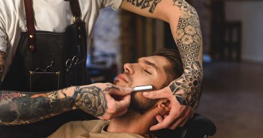 selective focus on barber shaving customer, concept of shaving